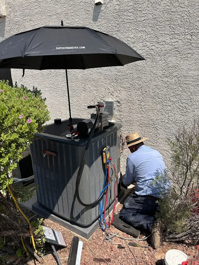 HVAC technician performing outdoor AC maintenance in Auburn Hills