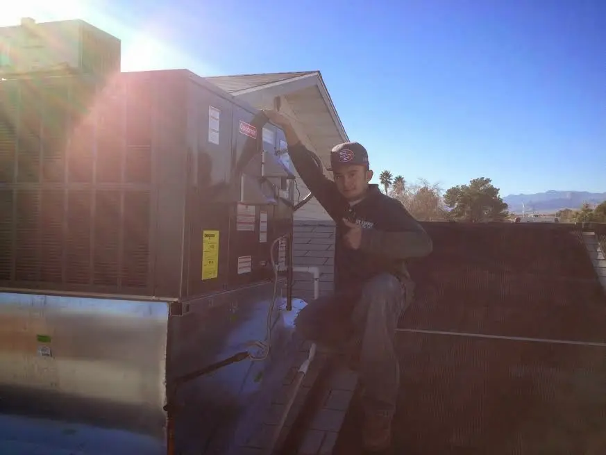 HVAC technician performing HVAC Inspection on a rooftop unit in Auburn Hills